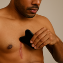 Man using Motivo gua sha stone for scar tissue massage and circulation improvement